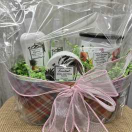 Gift basket with body lotion, shea butter balm, and a pink ribbon