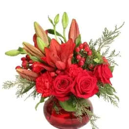 Red roses and lilies arranged in a red glass vase