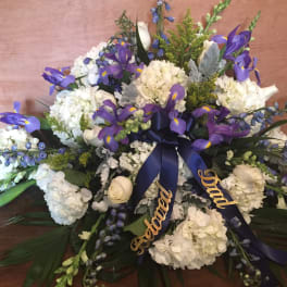 White and purple floral spray with ribbon on a table