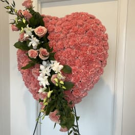 Pink floral heart on an easel with roses and white orchids