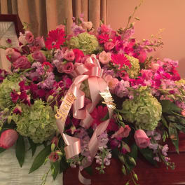 Large pink and green floral casket spray with ribbon