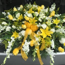Yellow and white floral spray with ribbon on a vehicle tailgate