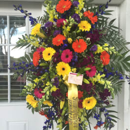 Large standing spray of multicolored gerbera daisies and snapdragons