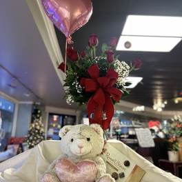 Bouquet of red roses with a pink heart balloon and teddy bear