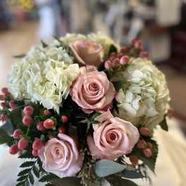 Bouquet of pink roses and white hydrangeas with berry accents