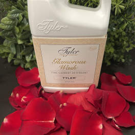 Tyler Glamorous Wash detergent bottle surrounded by red rose petals