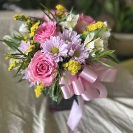 Pink roses and lavender daisies in a ribbon-tied bouquet
