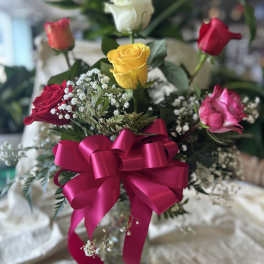 Bouquet of multicolored roses with a pink ribbon bow