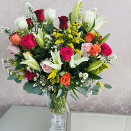 Mixed rose and lily bouquet in a clear glass vase