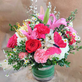 Pink and red mixed bouquet in a glass vase with a butterfly decoration