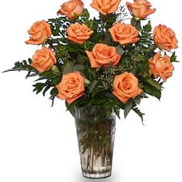 Orange roses arranged in a clear glass vase