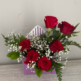 Bouquet of red roses with baby's breath in a purple gift box