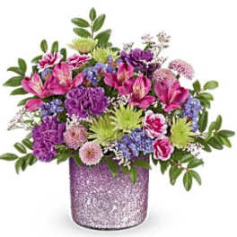 Mixed pink, purple, and green flowers in a glittery lavender vase