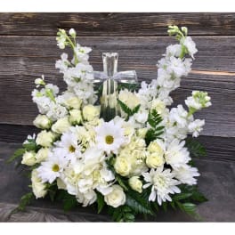 White floral arrangement with a clear glass cross centerpiece