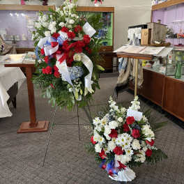Two large floral standing sprays with red, white, and blue flowers