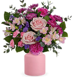 Pink and purple flower arrangement in a pink vase