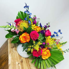 Colorful bouquet of roses and mixed flowers in a white vase
