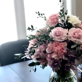 Pink and white carnations in a clear glass vase