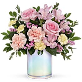 Pink and cream flowers arranged in an iridescent glass vase