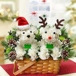 Basket arrangement with two white flower animal figures and Christmas accents