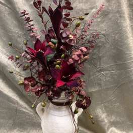 Deep burgundy floral arrangement in a white vase