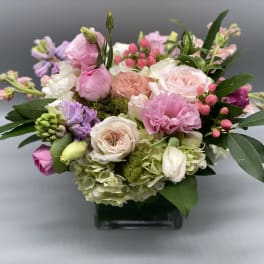 Pink and white mixed bouquet in a square glass vase
