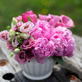 Pink bouquet of peonies and lisianthus in a white vase