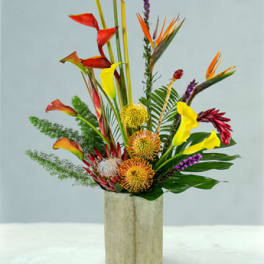Tropical flower arrangement in a tall rectangular vase