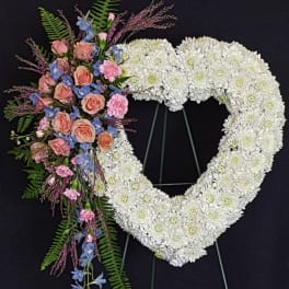 Heart-shaped white floral wreath with a pink and blue flower spray