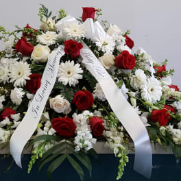 Casket spray of red and white roses with white daisies and ribbon