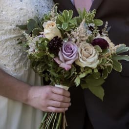 Bride holding a bouquet of roses and greenery