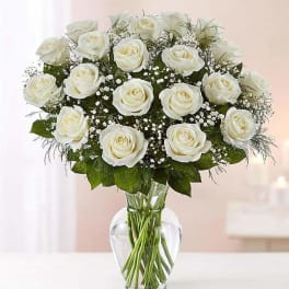 White roses arranged in a clear glass vase