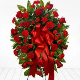 Red rose and carnation standing spray with a large red ribbon