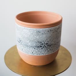 Terracotta planter with a white floral lace pattern band