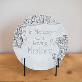 Round memorial plaque reading In Memory of a Loving Mother on a stand