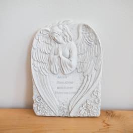 White angel memorial plaque with engraved text and flowers