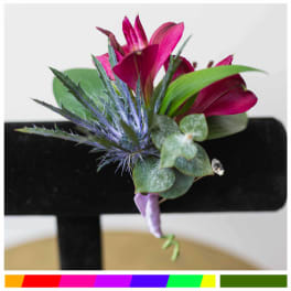 Magenta boutonniere with spiky blue thistle and green leaves