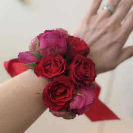 Red and pink rose wrist corsage with ribbon ties