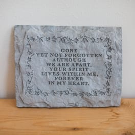 Stone memorial plaque with an engraved remembrance message