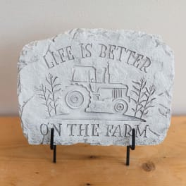 Stone plaque with a tractor and the words "Life is Better on the Farm"