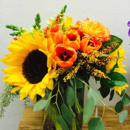 Sunflower and orange tulip bouquet in a glass vase
