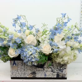 Blue and white floral arrangement in a decorative rectangular box