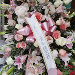 Large pink and white sympathy wreath with a ribbon sash