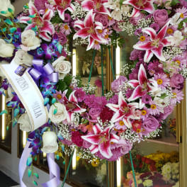 Large heart-shaped floral standing wreath with pink lilies and roses