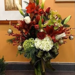 Tall red and white floral arrangement in a glass vase