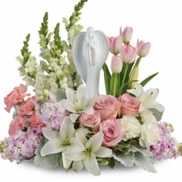 Pink and white floral arrangement with a white angel figurine