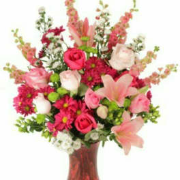 Pink and white mixed bouquet in a red glass vase