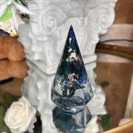 Faceted dark blue crystal ornament in front of white roses