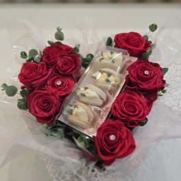 Bouquet of red roses with a box of macarons in the center