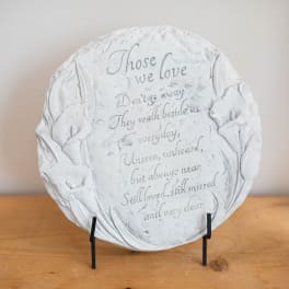 Round memorial plaque with engraved flowers and a sympathy poem